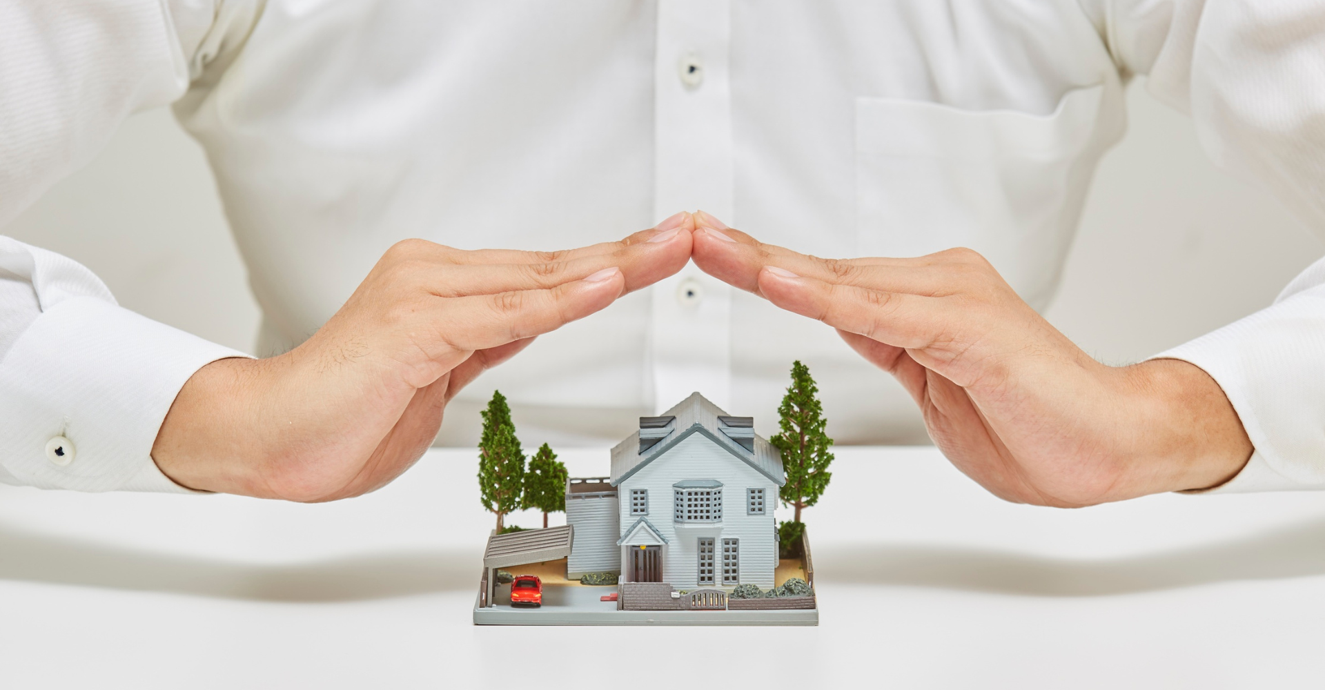 Hands over toy house.